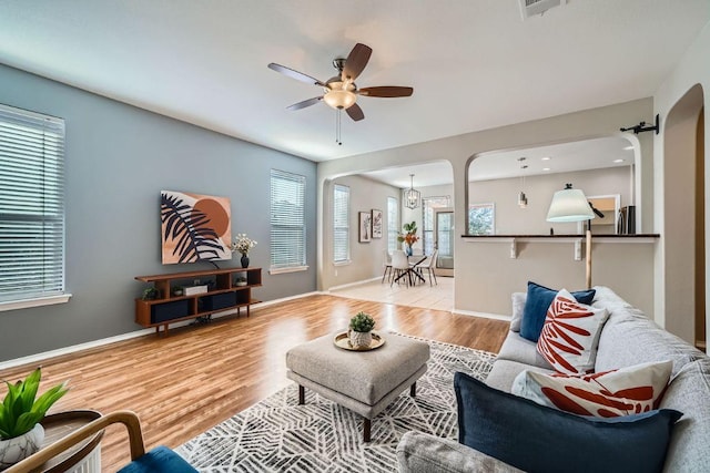 living area featuring ceiling fan, wood finished floors, and baseboards