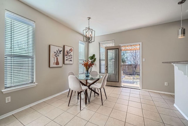 dining space with baseboards, light tile patterned flooring, and an inviting chandelier