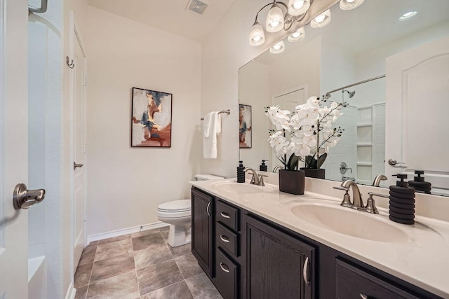 bathroom featuring double vanity, baseboards, visible vents, and a sink