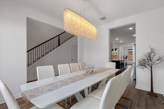 dining space featuring stairway, baseboards, wood finished floors, and visible vents