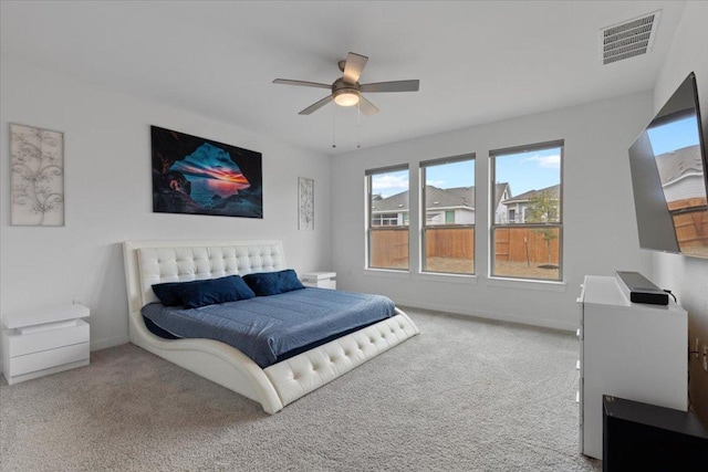 carpeted bedroom featuring a ceiling fan, baseboards, and visible vents