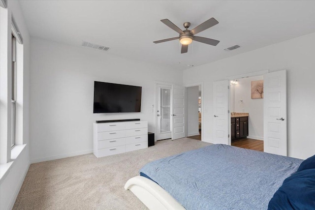 carpeted bedroom with baseboards, a ceiling fan, connected bathroom, and visible vents