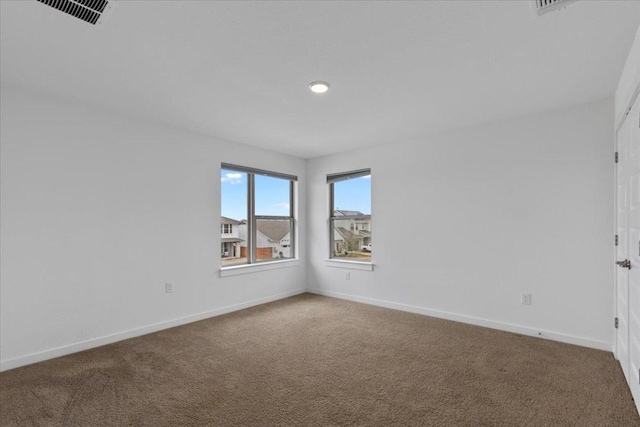 carpeted spare room featuring baseboards, recessed lighting, and visible vents