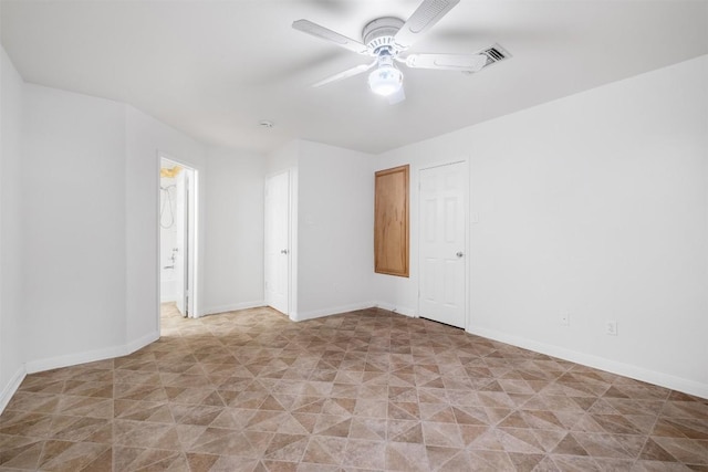 spare room with ceiling fan, visible vents, and baseboards