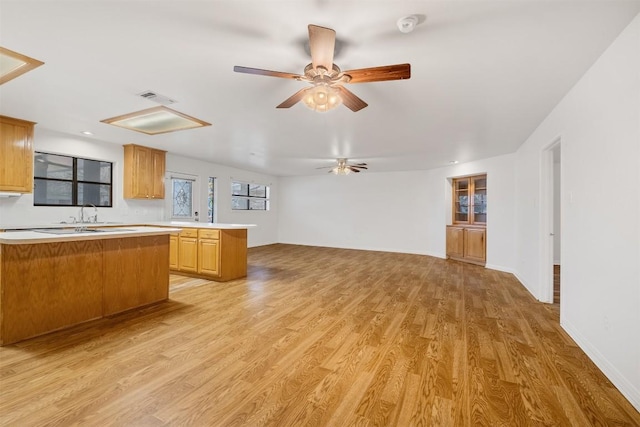 kitchen featuring light wood-style floors, ceiling fan, visible vents, and light countertops