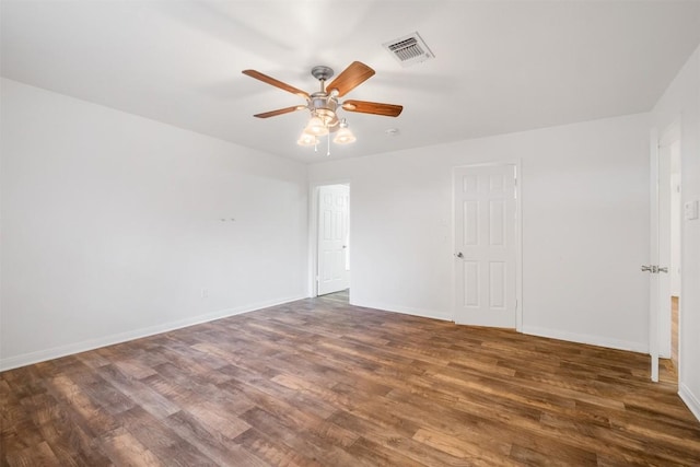 empty room featuring visible vents, ceiling fan, baseboards, and wood finished floors