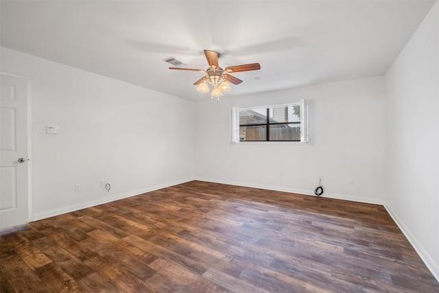 spare room with a ceiling fan, visible vents, baseboards, and wood finished floors