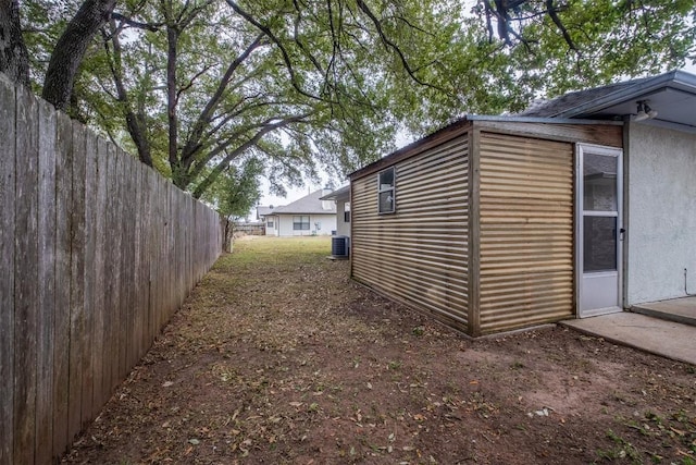 view of property exterior with cooling unit and fence