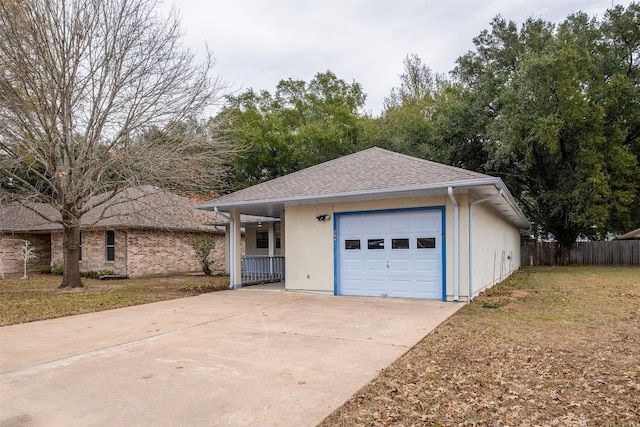 garage featuring concrete driveway and fence