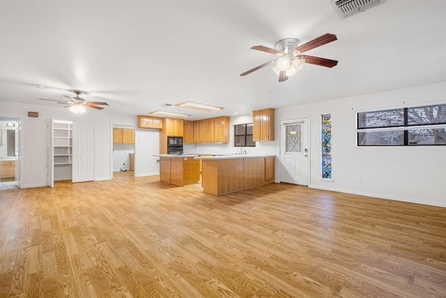 kitchen with open floor plan, light wood finished floors, and visible vents