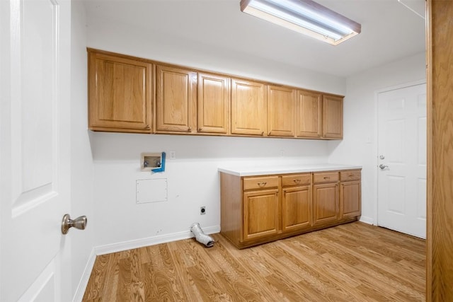 clothes washing area featuring washer hookup, cabinet space, light wood-style flooring, hookup for an electric dryer, and baseboards