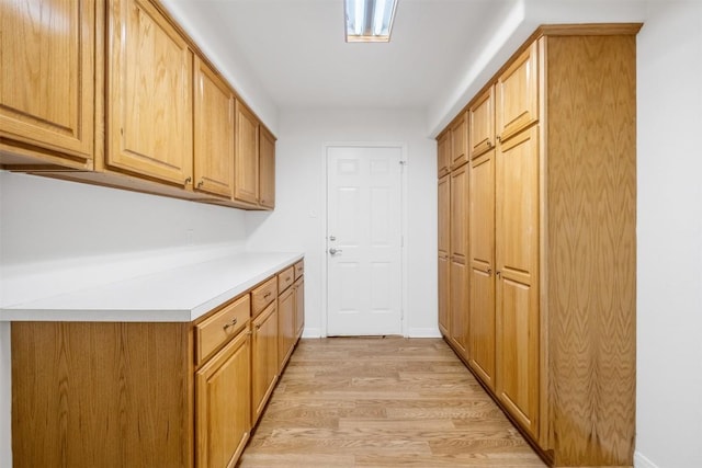 kitchen with light countertops, light wood-style flooring, and baseboards