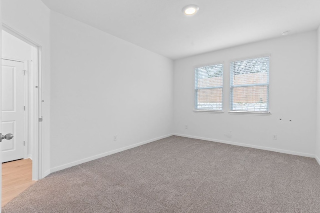 empty room with light carpet and baseboards