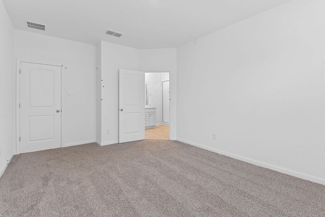 unfurnished bedroom with light carpet, baseboards, and visible vents