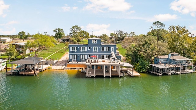 back of house with a deck with water view and boat lift