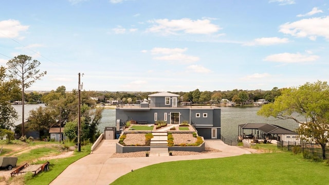 surrounding community with stairs, a yard, and a water view