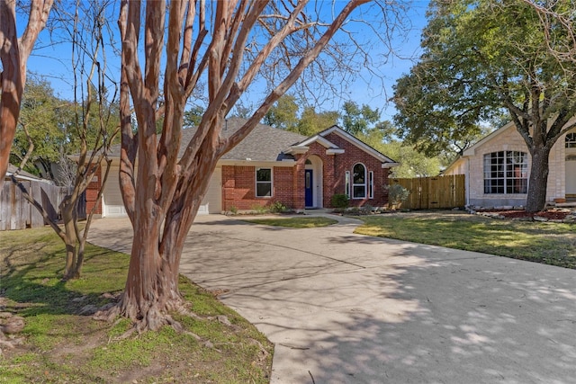 view of front of home with concrete driveway, an attached garage, fence, a front lawn, and brick siding