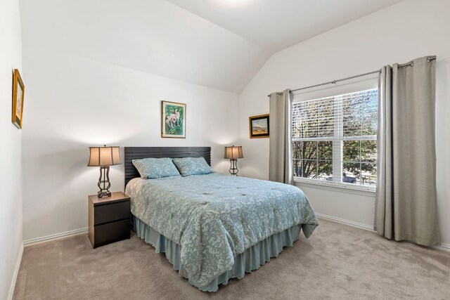 bedroom featuring vaulted ceiling, baseboards, and light colored carpet