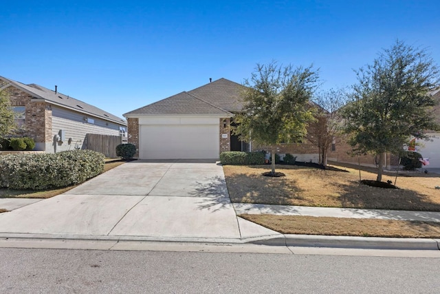 view of front facade with concrete driveway, brick siding, an attached garage, and fence