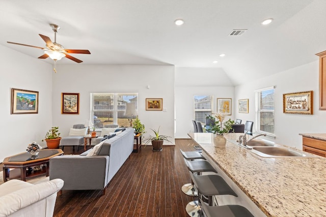 living room with vaulted ceiling, dark wood finished floors, visible vents, and a healthy amount of sunlight