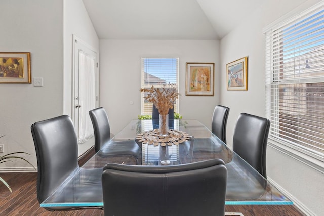 dining area featuring lofted ceiling, wood finished floors, and baseboards