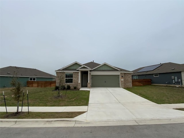 view of front of home with brick siding, an attached garage, fence, driveway, and a front lawn