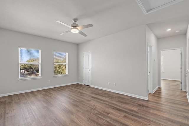 empty room featuring a ceiling fan, baseboards, and wood finished floors