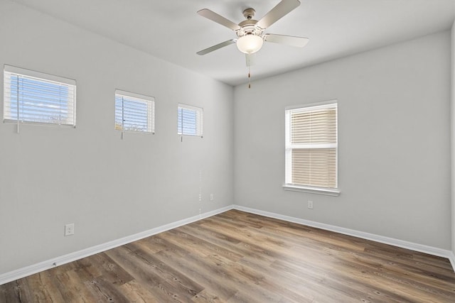 spare room with ceiling fan, baseboards, and wood finished floors