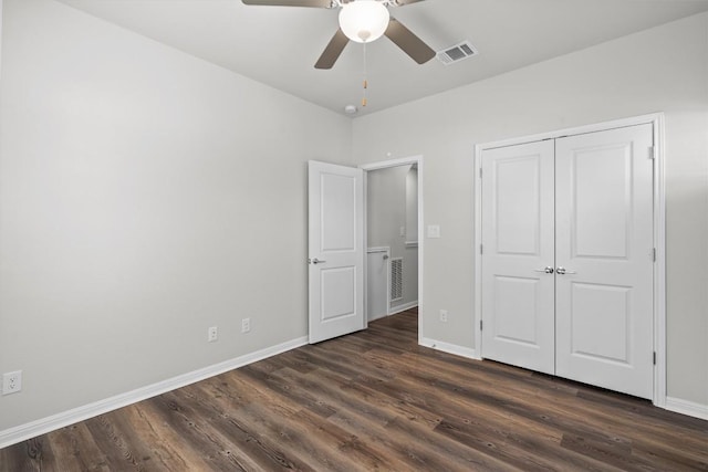 unfurnished bedroom with dark wood-style floors, baseboards, and visible vents