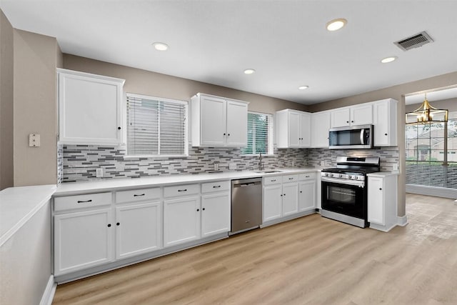 5008 Barlow Dr, Round Rock, TX 78681 - kitchen with appliances with stainless steel finishes, plenty of natural light, white cabinetry, light wood-style floors, and recessed lighting