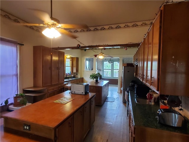 422 W N Main St, Flatonia, TX 78941 - kitchen with a center island, a ceiling fan, brown cabinets, dark countertops, and wood finished floors