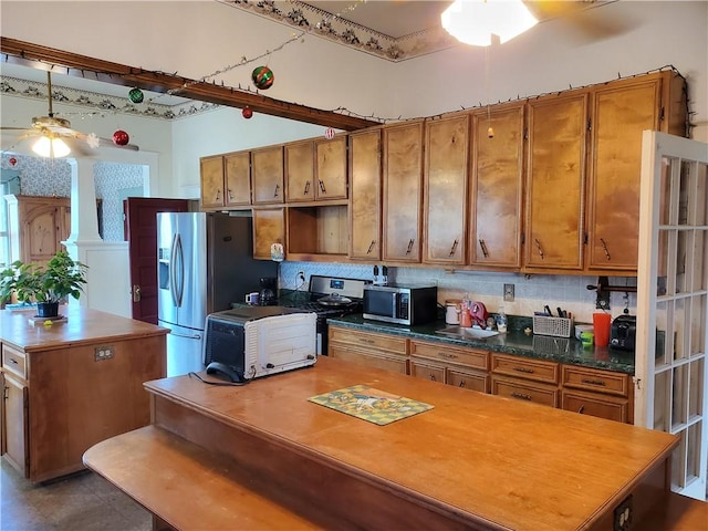 kitchen featuring tasteful backsplash, a ceiling fan, appliances with stainless steel finishes, brown cabinets, and a center island