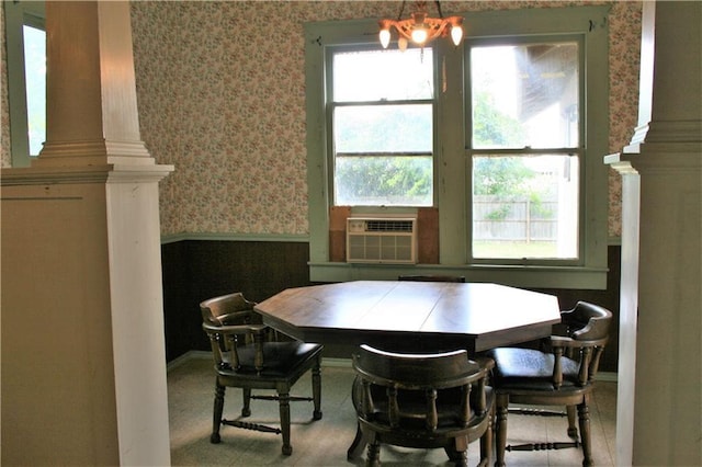 dining room featuring a wealth of natural light, cooling unit, wainscoting, and wallpapered walls