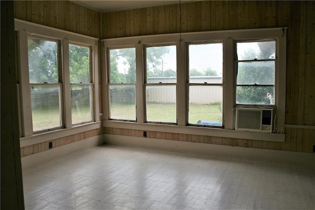 unfurnished sunroom featuring cooling unit and a healthy amount of sunlight