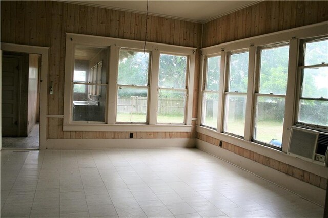 422 W N Main St, Flatonia, TX 78941 - unfurnished sunroom with wood walls, healthy amount of natural light, tile patterned floors, and cooling unit