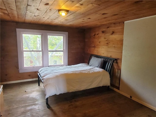 bedroom featuring wooden ceiling, wood-type flooring, wooden walls, and baseboards