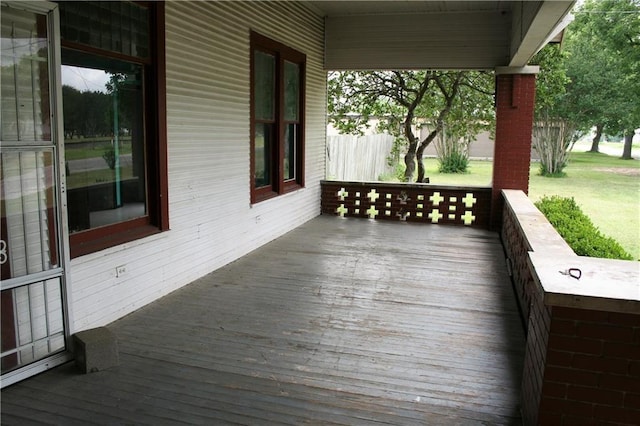 wooden terrace featuring a yard and fence