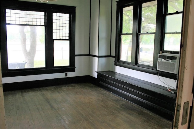 unfurnished room with dark wood-style floors, cooling unit, and baseboards