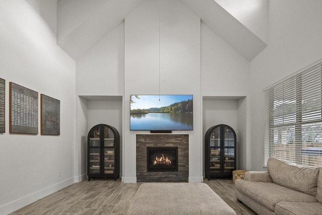 5824 Antelope Well Ln, Austin, TX 78738 - living room with high vaulted ceiling, wood finish floors, a warm lit fireplace, and baseboards