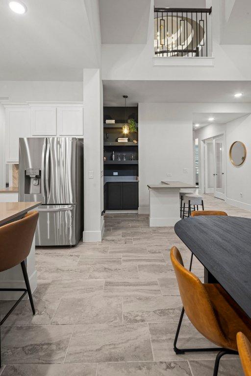 dining area with a high ceiling and baseboards