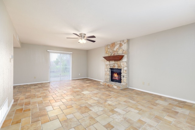 unfurnished living room featuring a ceiling fan, visible vents, a stone fireplace, and baseboards