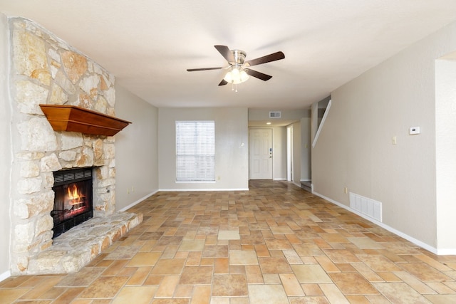 unfurnished living room featuring a ceiling fan, visible vents, a fireplace, and baseboards