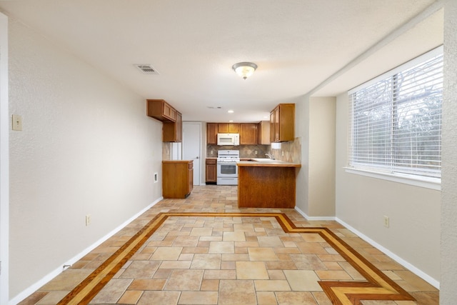 kitchen featuring white appliances, baseboards, visible vents, brown cabinetry, and light countertops