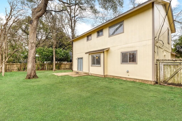 back of property featuring fence and a lawn