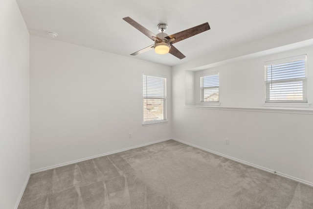 empty room featuring carpet floors, ceiling fan, and baseboards