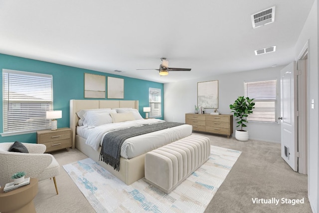 bedroom featuring ceiling fan, light carpet, and visible vents