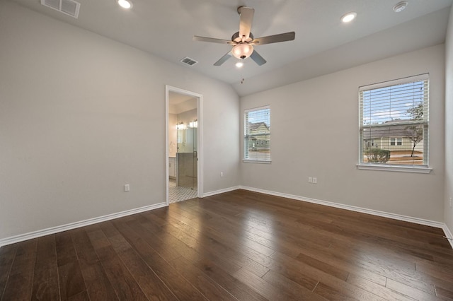 unfurnished room with ceiling fan, dark wood finished floors, visible vents, and baseboards