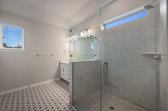 bathroom featuring a stall shower, baseboards, and vanity