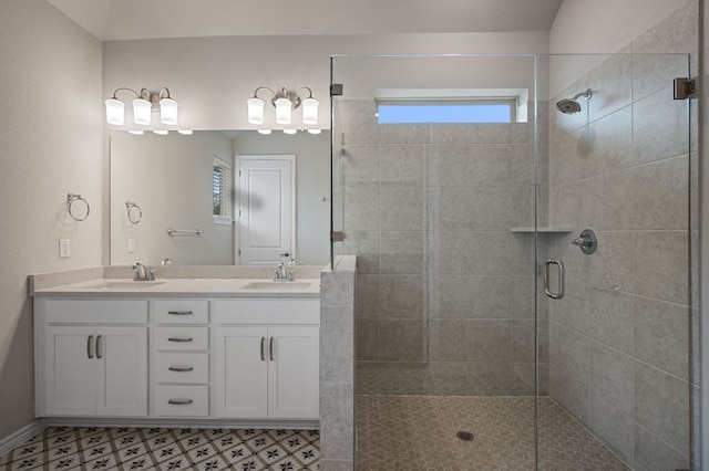 bathroom with a sink, a shower stall, and double vanity