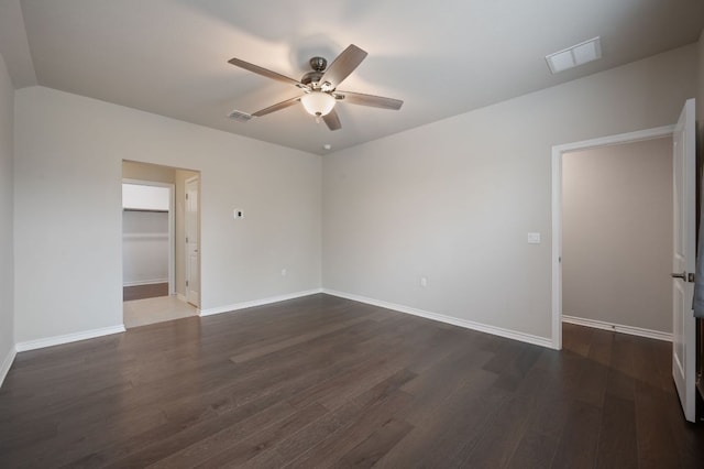 unfurnished room with a ceiling fan, baseboards, visible vents, and dark wood-style flooring